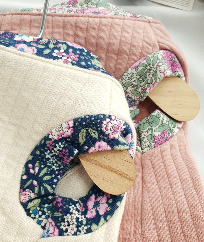 Floral ribbed modern pet hanbok in cream and pink with decorative wooden accents.