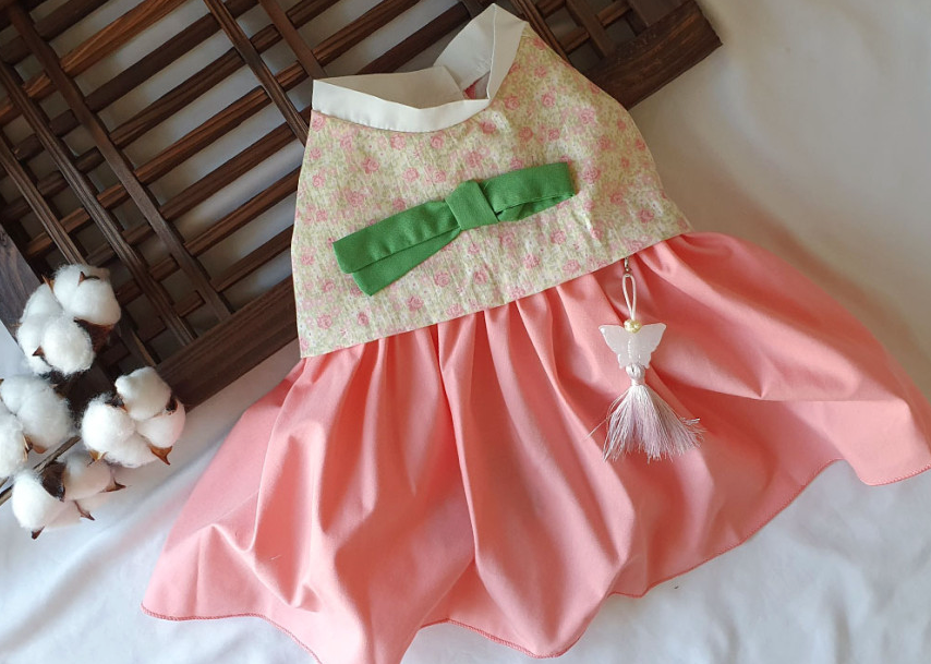 NKpup floral bow pet hanbok with a pink skirt, floral top, green bow, and a white norigae tassel.
