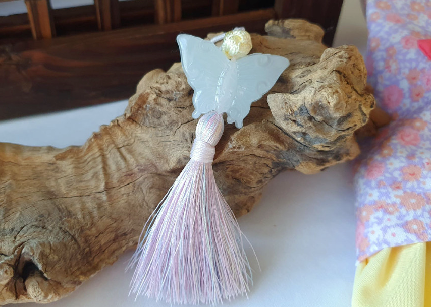 White butterfly norigae charm with a light pink tassel for a NKpup Floral Bow Pet Hanbok