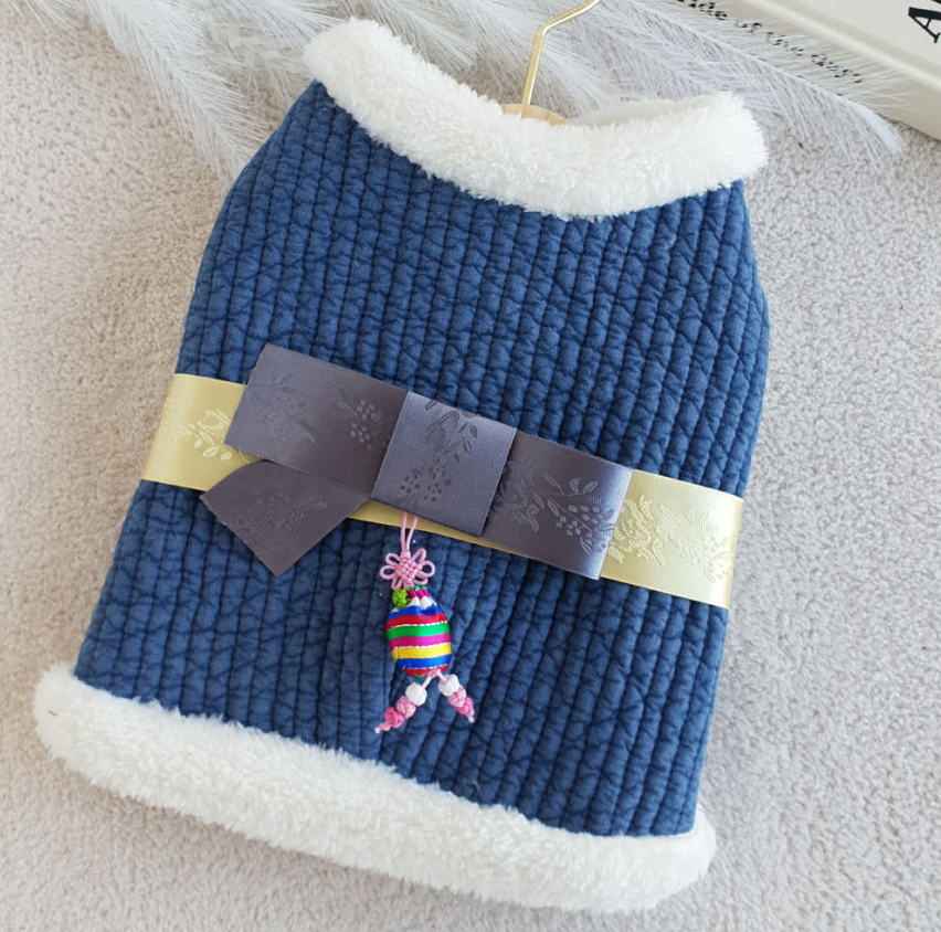 Blue quilted cotton pet hanbok vest with white fleece trim, a gold ribbon, and a colorful norigae charm.