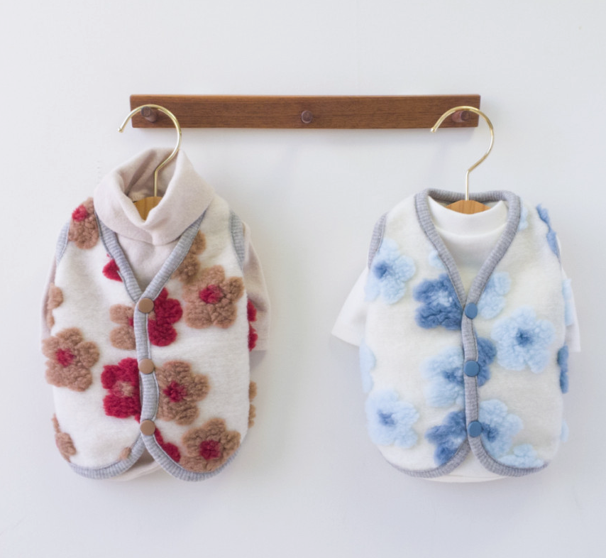 Two NKpup floral fleece dog vests, one with red and brown flowers and one with blue flowers.