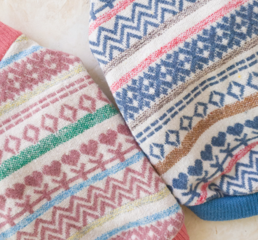 Jacquard knit dog cardigan featuring pink and blue geometric and heart patterns.