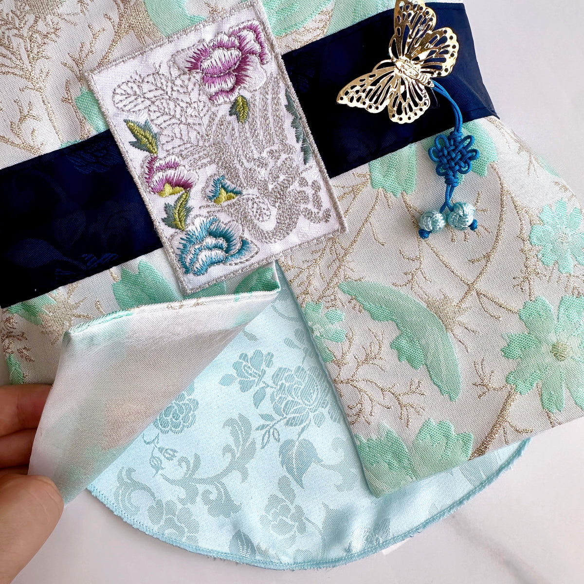Flower pattern pet hanbok vest with gold butterfly ornament and blue norigae detail