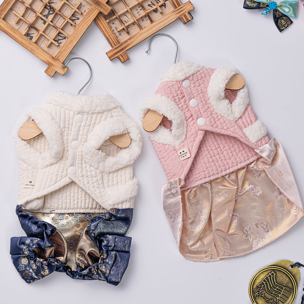 Two baby rompers on hangers with decorative bows and wooden toys on a light background