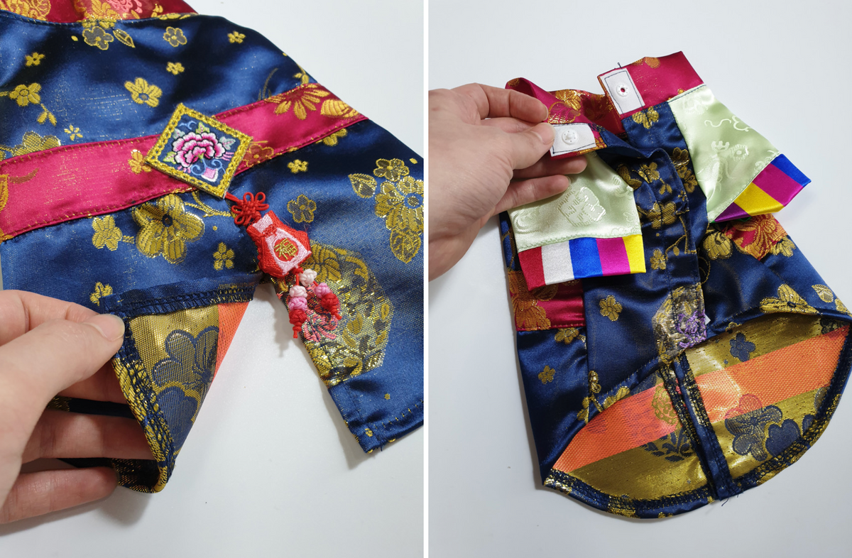 Blue silk pet hanbok with gold floral patterns and pink embroidery details.