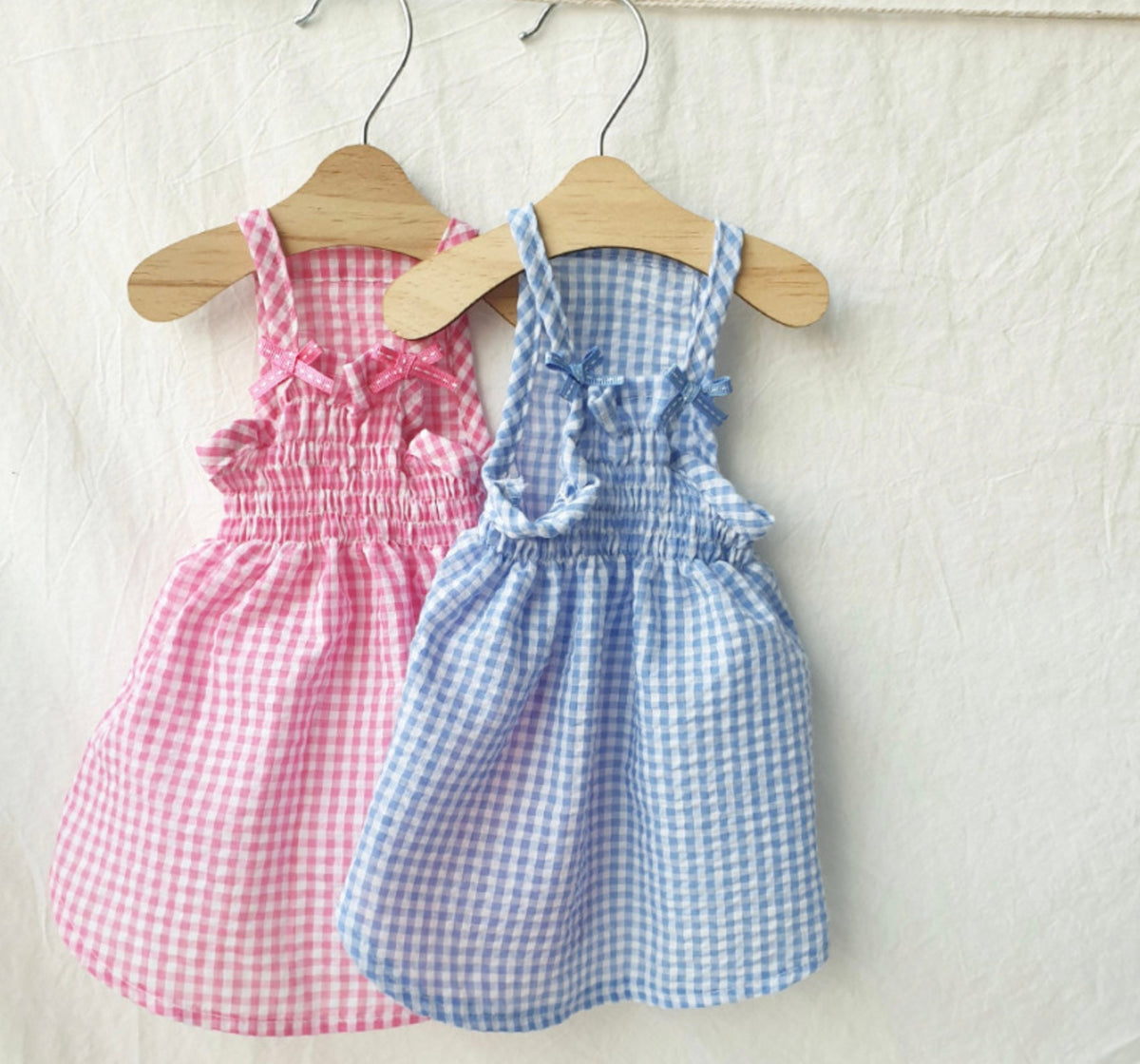 Vintage gingham dog dresses in pink and blue with ruffle details