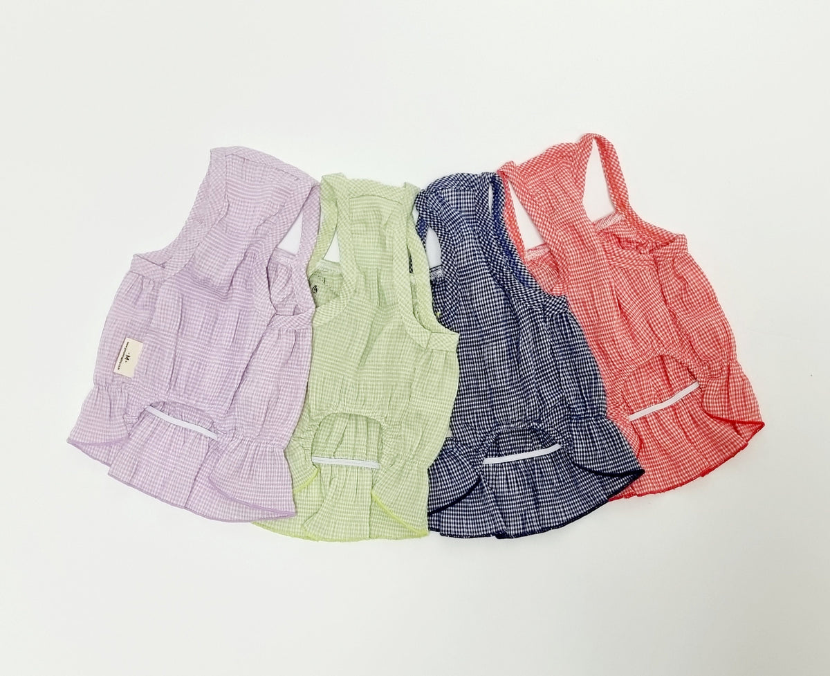 Three colorful gingham fruit patch dog tank tops in lavender, light green, navy, and red.