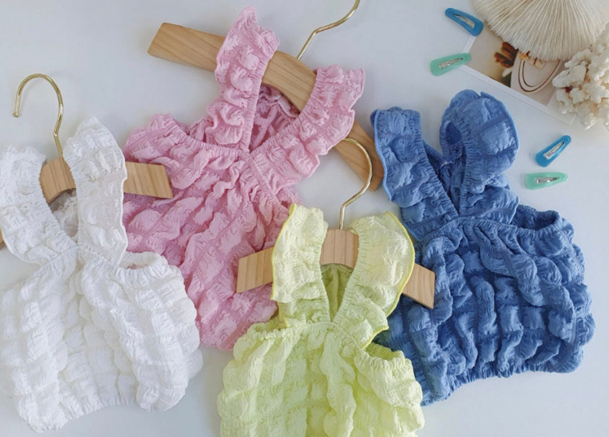 Four textured ruffle dog crop tank tops in white, pink, yellow, and blue.