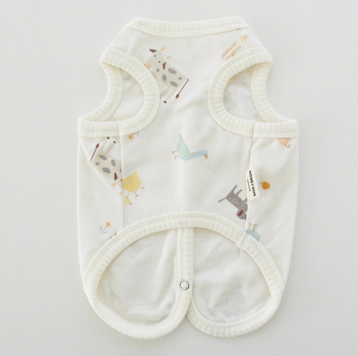 White organic cotton dog vest with a colorful animal zoo pattern
