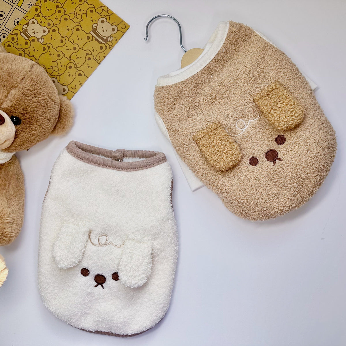 Two NKpup downy fleece dog vests in beige and white with cute bunny ears design.