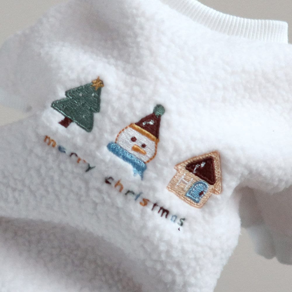 Close-up of a white NKpup Christmas fleece dog sweater with embroidered holiday icons and 'merry christmas' text.