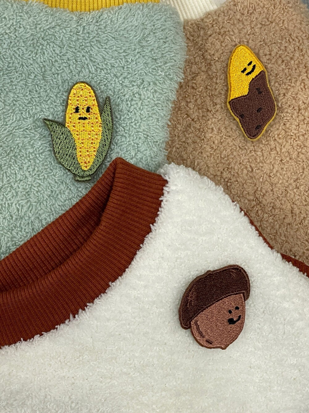 Harvest Patch Dog Fleece Vest featuring embroidered corn and acorn details on textured fabrics.