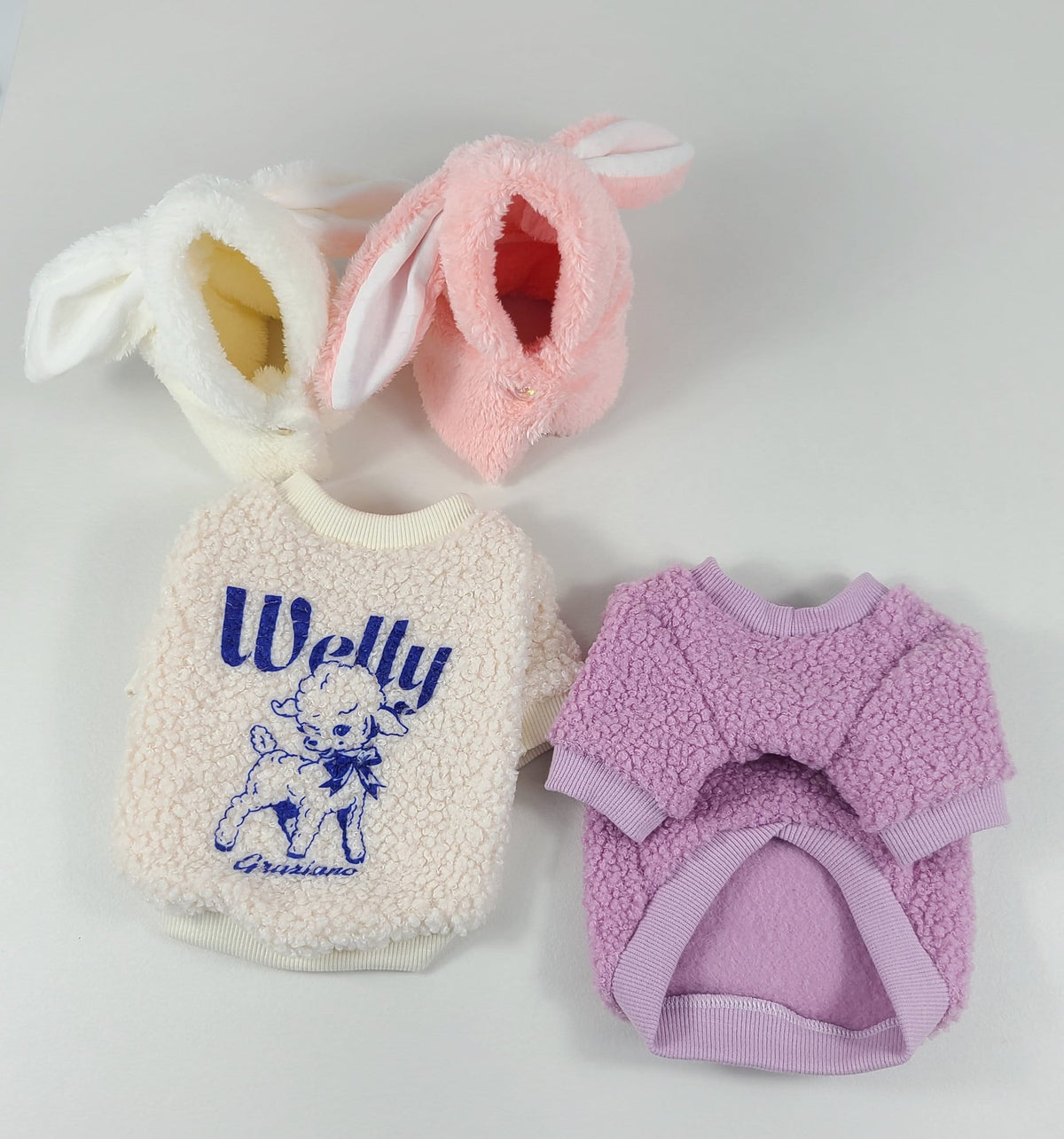 NKpup Welly Fleece Dog Sweatshirt in cream with blue embroidery and two pink bunny ear hats.