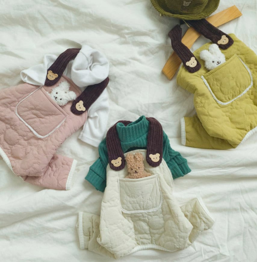Three sets of NKpup padded dog overalls in pink, green, and yellow with small teddy bear accents.