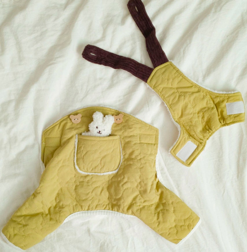 Yellow quilted pocket padded dog overall with dark brown ribbed leg straps.