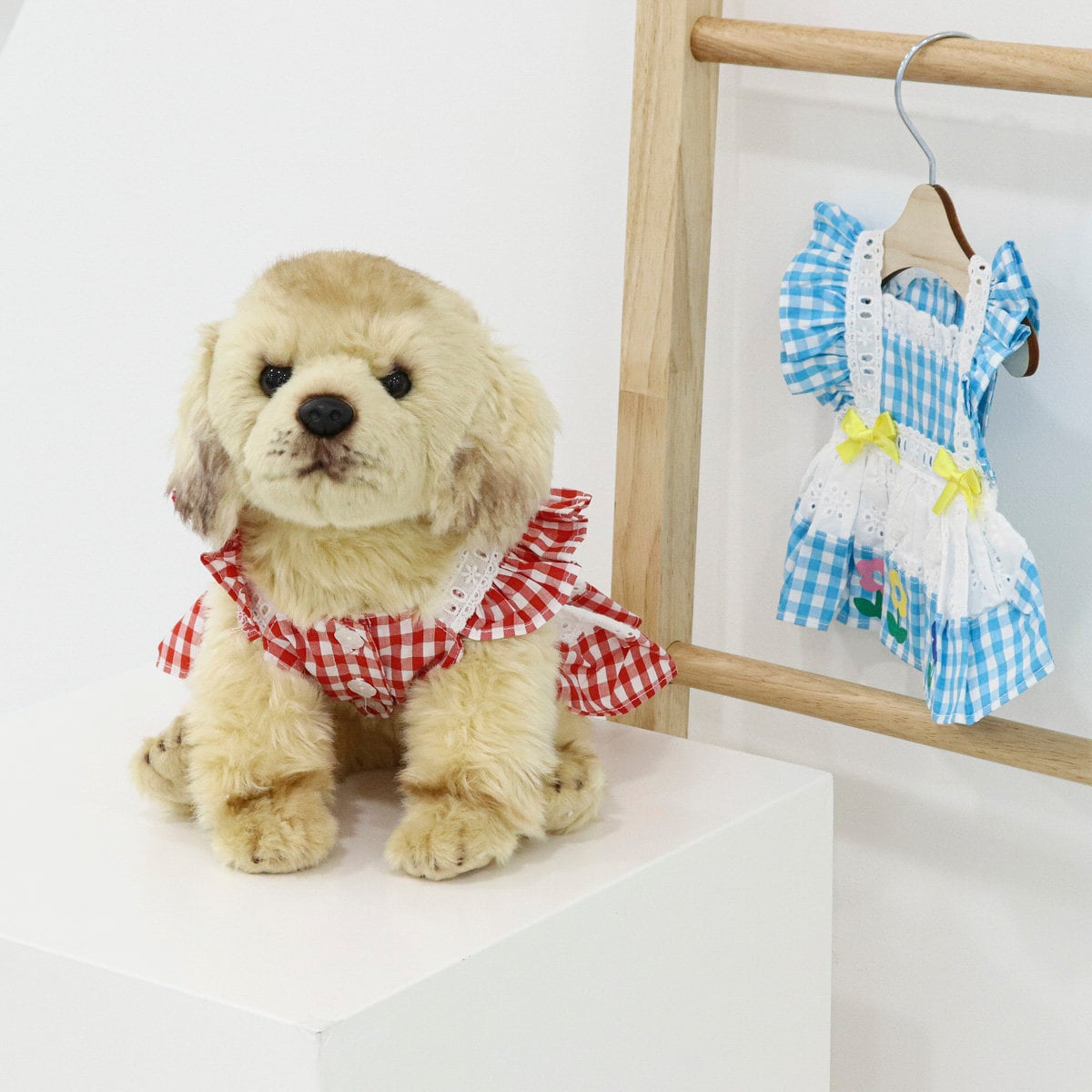 A blue and white checkered flower pinafore dog dress with white lace trim and yellow bows.