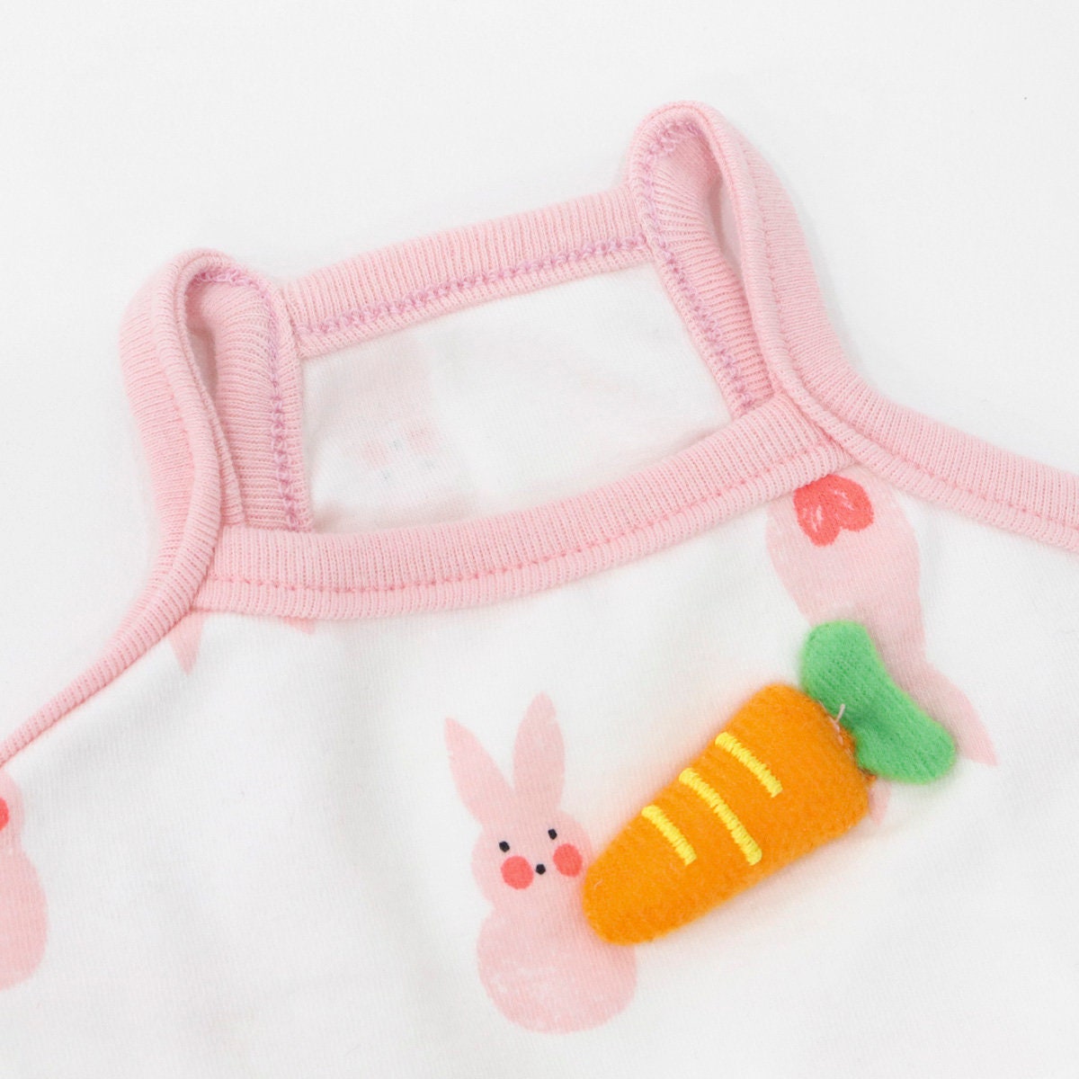 White NKpup dog tank top with pink trim and a cute rabbit and carrot pattern.