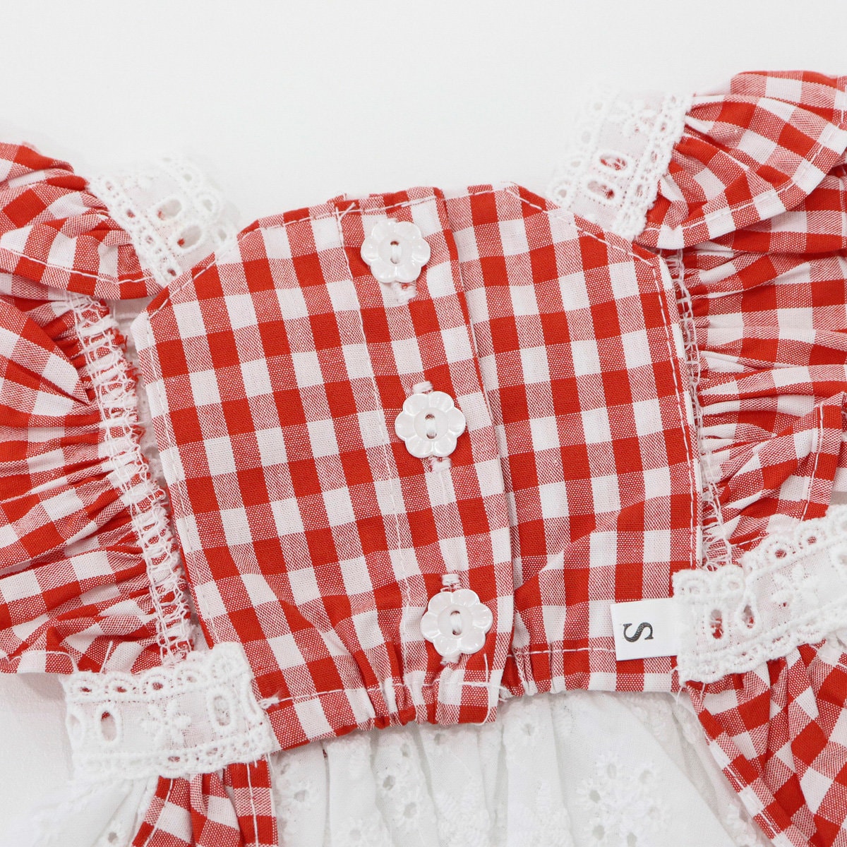 Red and white checkered flower pinafore dog dress with white lace trim and flower buttons.