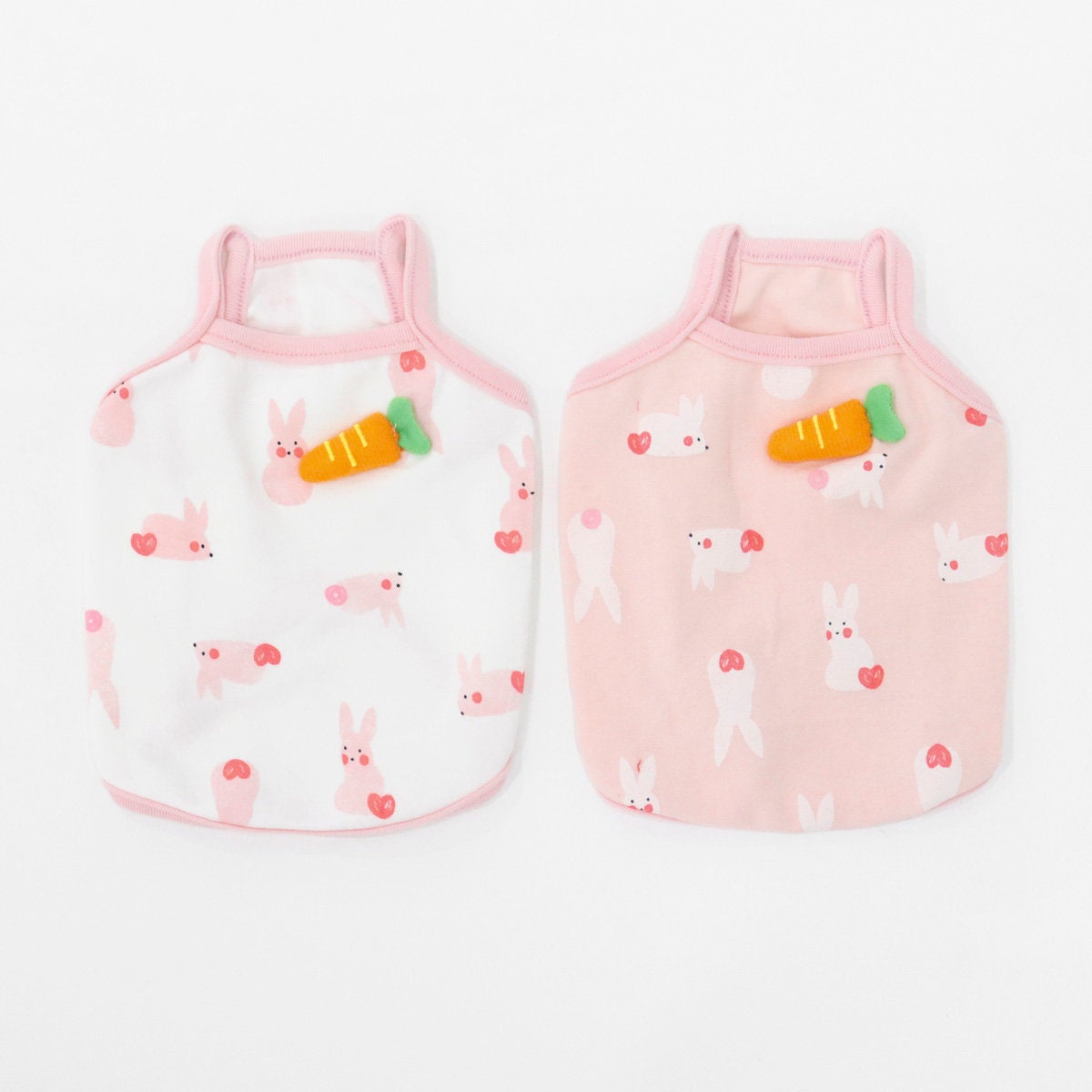 Two NKpup rabbit and carrot pattern dog tank tops in white and pink.