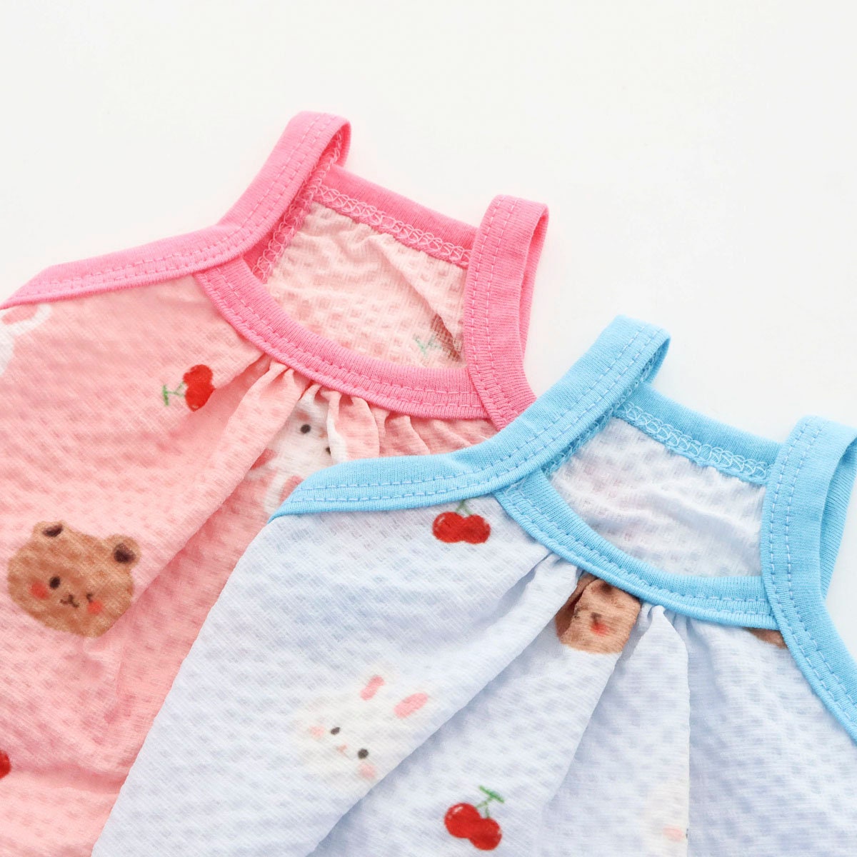 NKpup Yoryu Play Top sleeveless dog shirts in pink and blue with bear and cherry patterns.