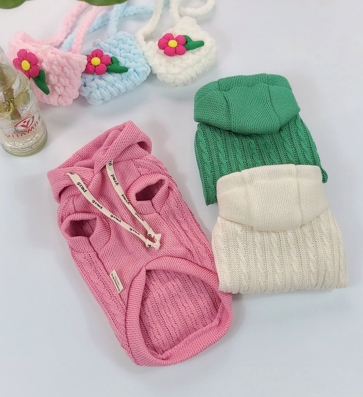 Pink cable knit dog hoodie and green and white cable knit dog sweater by NKpup