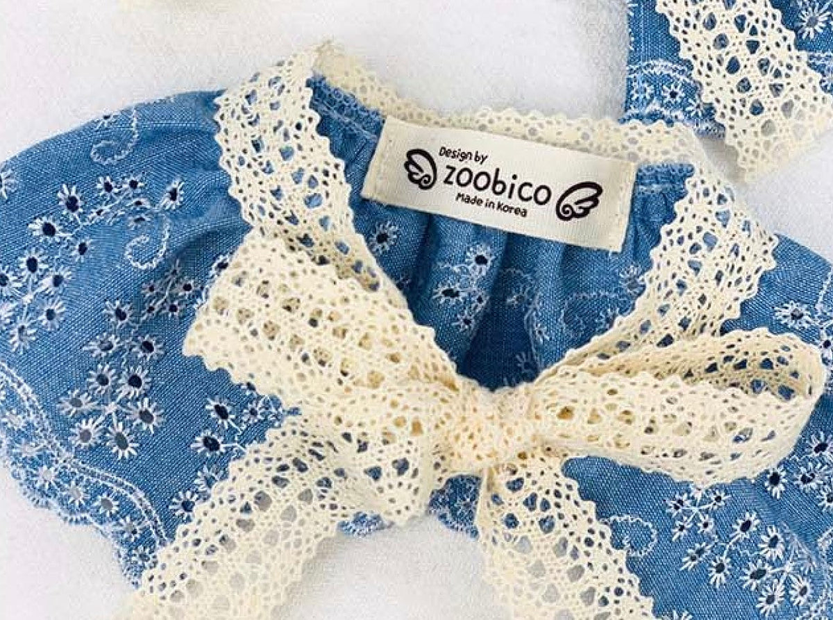 Blue denim lace dog cape with floral patterns and cream lace trim