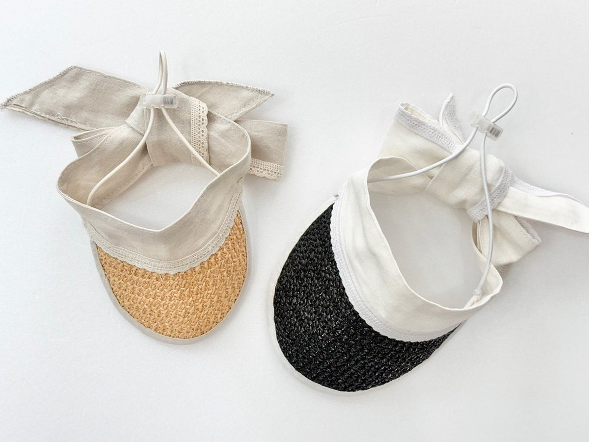 Two NKpup charming straw sun hats for pets, one in natural tan and one in black, with cream fabric ties.