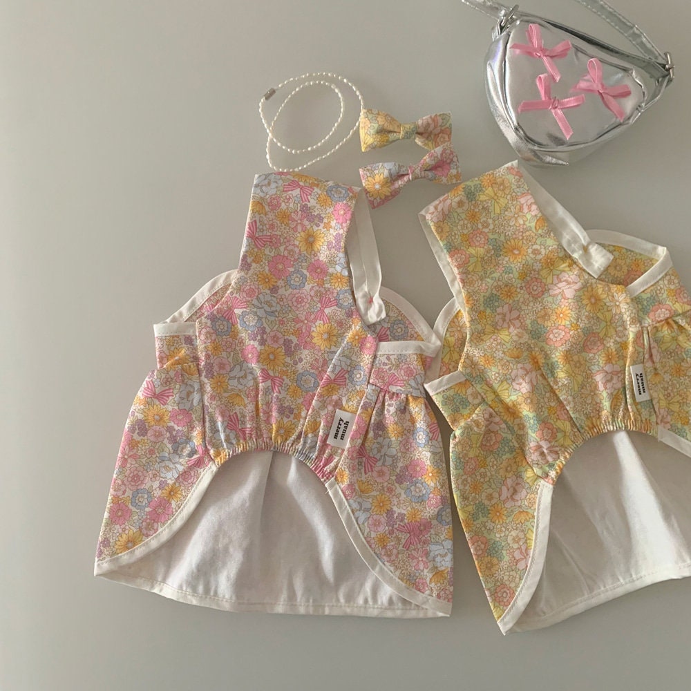 NKpup vintage floral dog dress in pink and yellow patterns with matching bows and a silver pet bag.