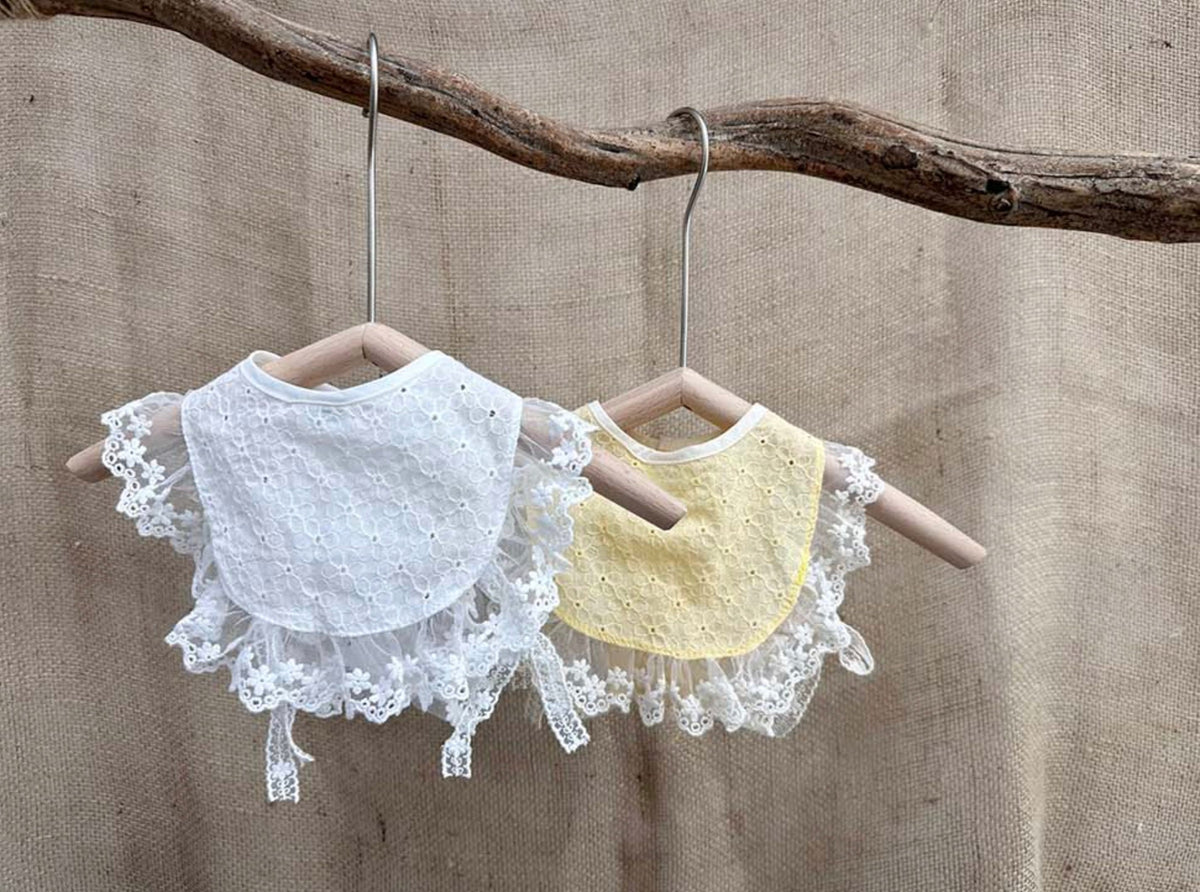 Two cotton lace bibs for pets, one white and one pale yellow, featuring delicate lace trim.