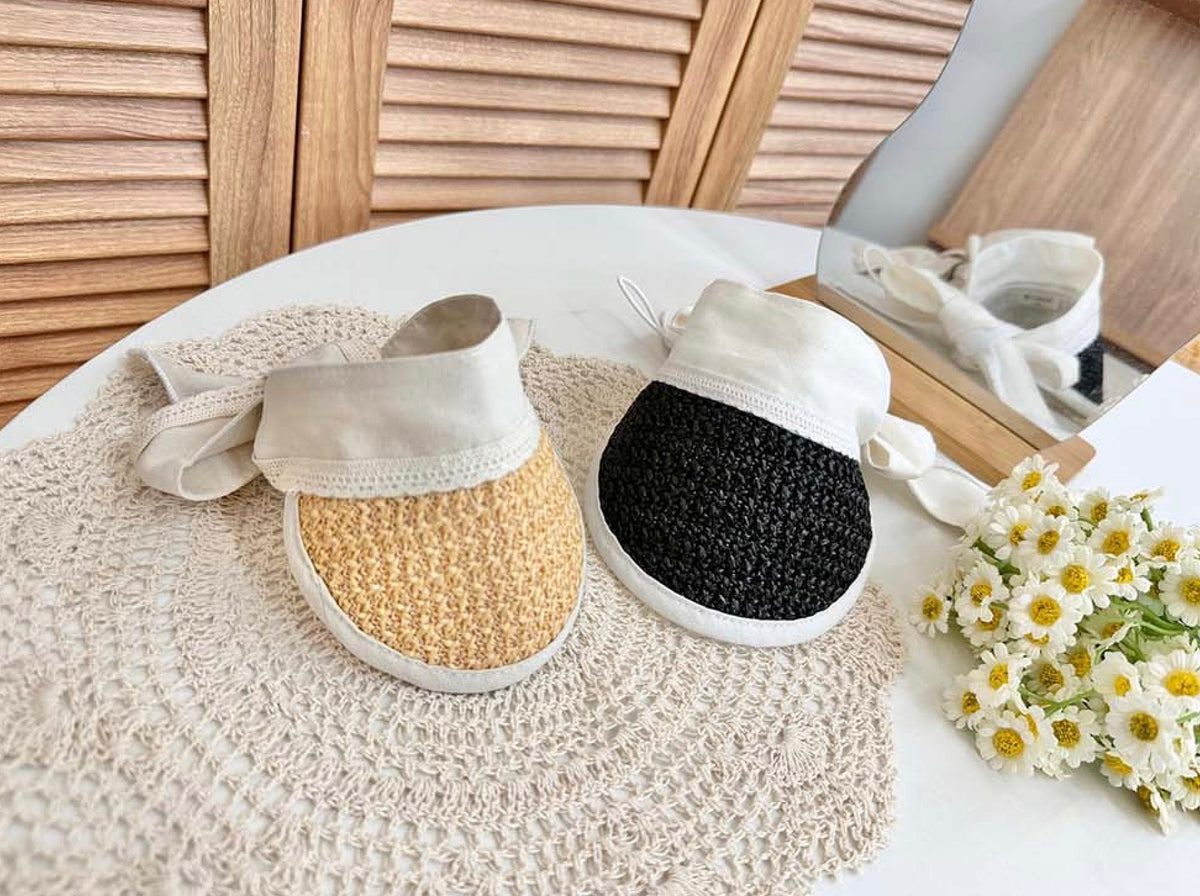Charming straw sun hats for pets in beige and black colors with white tie straps.