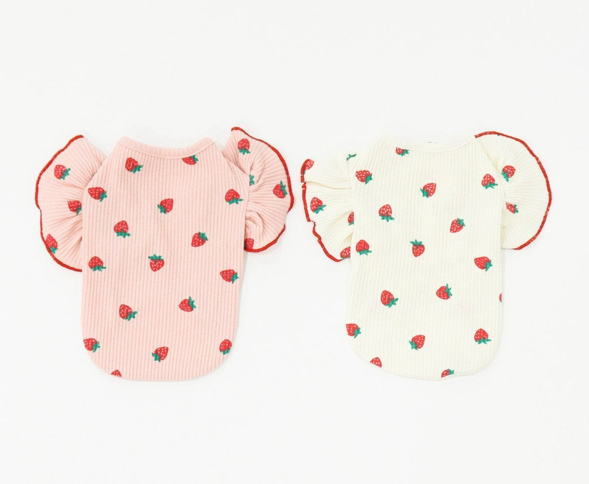 Two NKpup strawberry print dog shirts with ruffle sleeves, one in pink and one in white.
