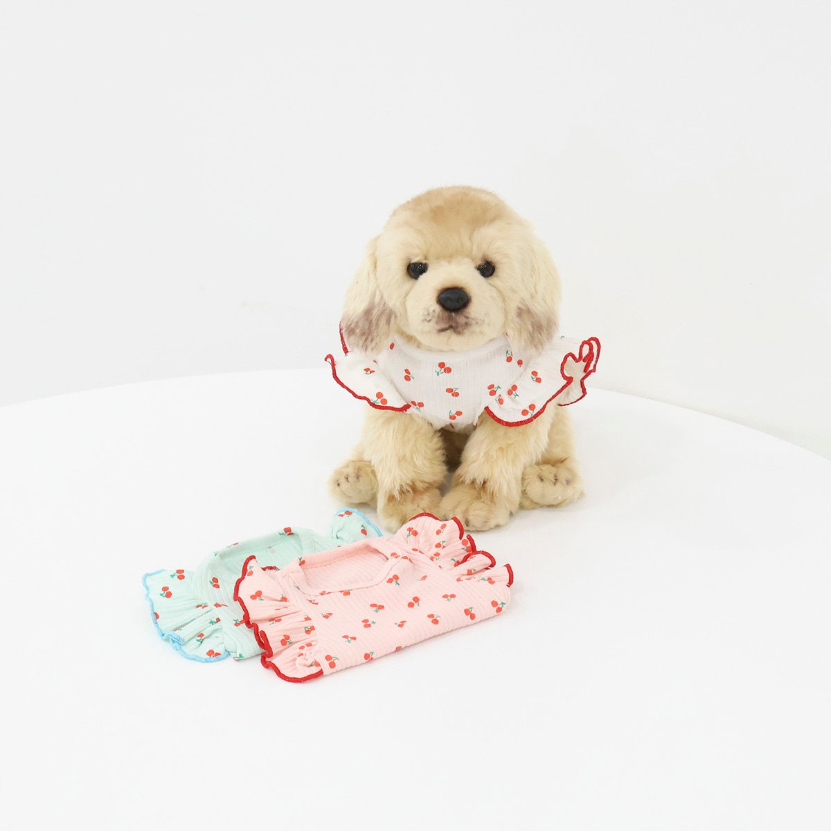 Cherry pattern ribbed dog shirts in pink and light blue with ruffled collars.