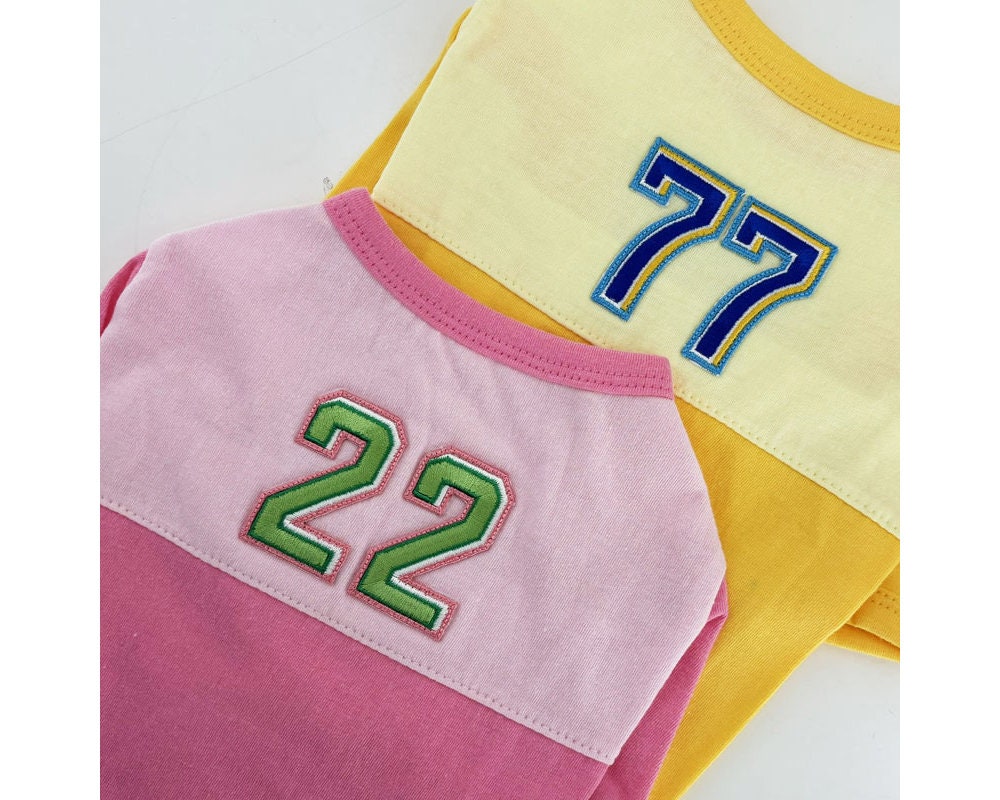 NKpup color-block dog shirts in pink and yellow with embroidered numbers 22 and 77