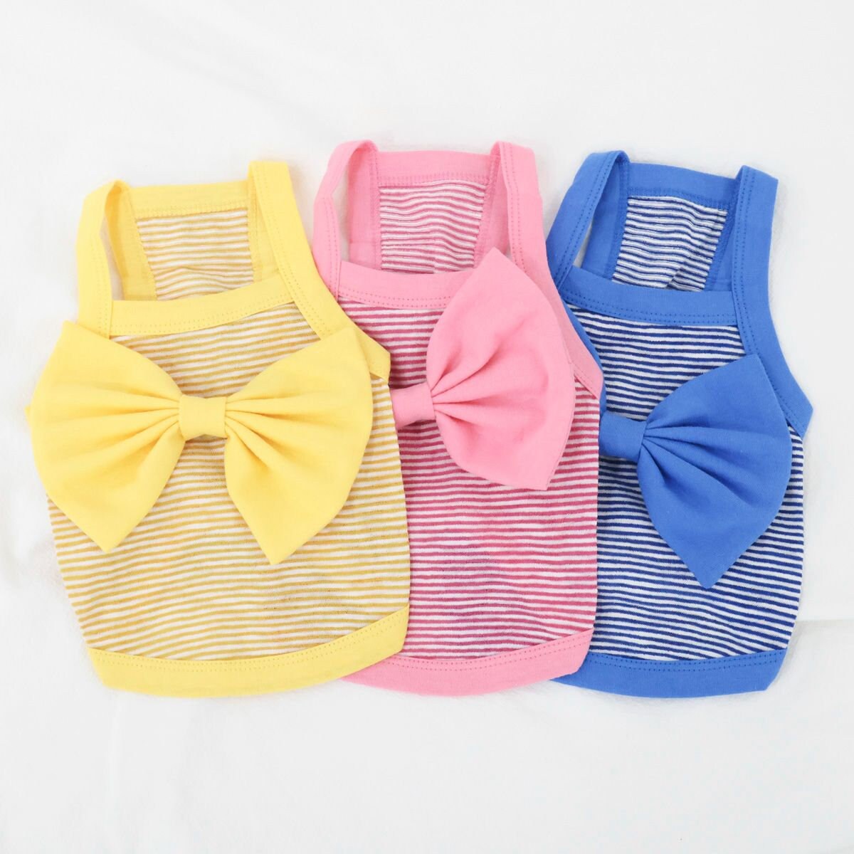 NKpup Ribbon Stripe Top dog shirts in yellow, pink, and blue with large decorative bows.