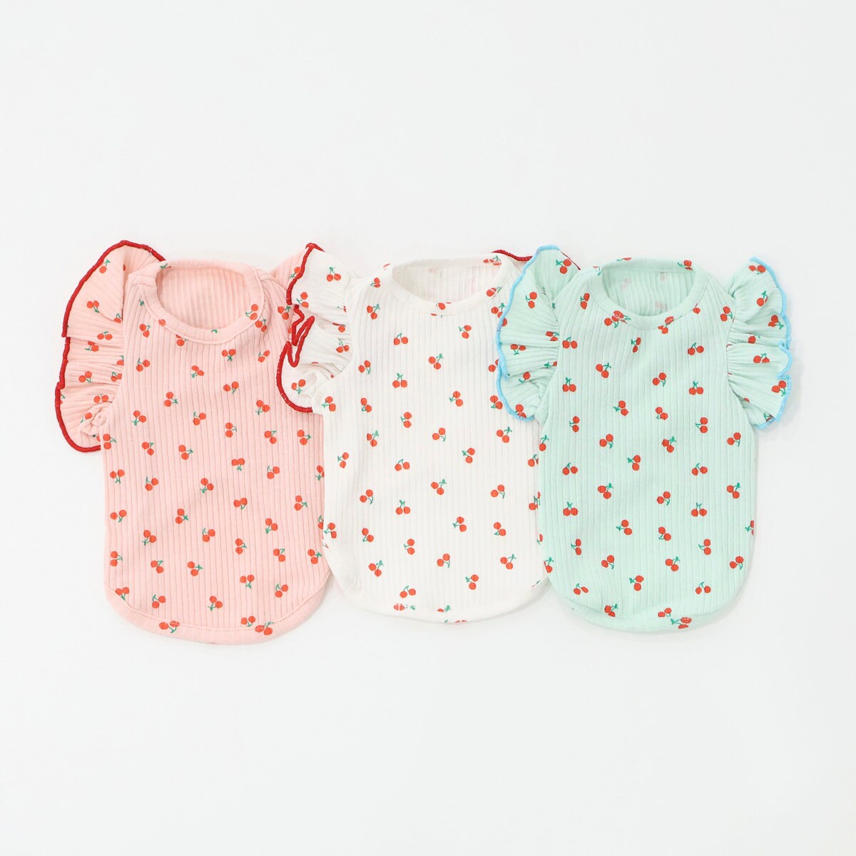 Cherry pattern ribbed dog shirts in pink, white, and mint green with ruffled sleeves