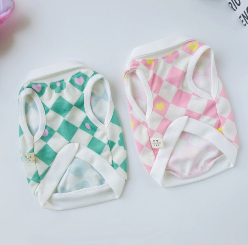 Two NKpup checkerboard flower dog shirts in green and pink patterns.
