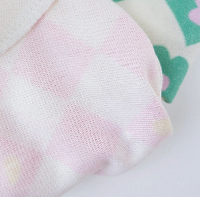 Pink and white checkerboard pattern dog shirt with green flower details