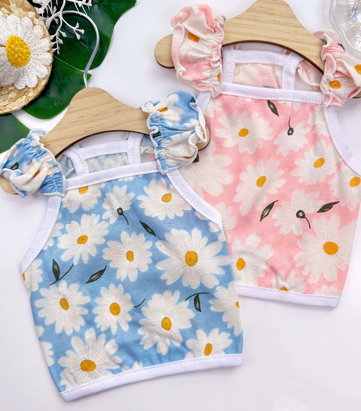 Two NKpup Daisy Ruffle Crop Tops for dogs in light blue and pink with white daisy patterns.