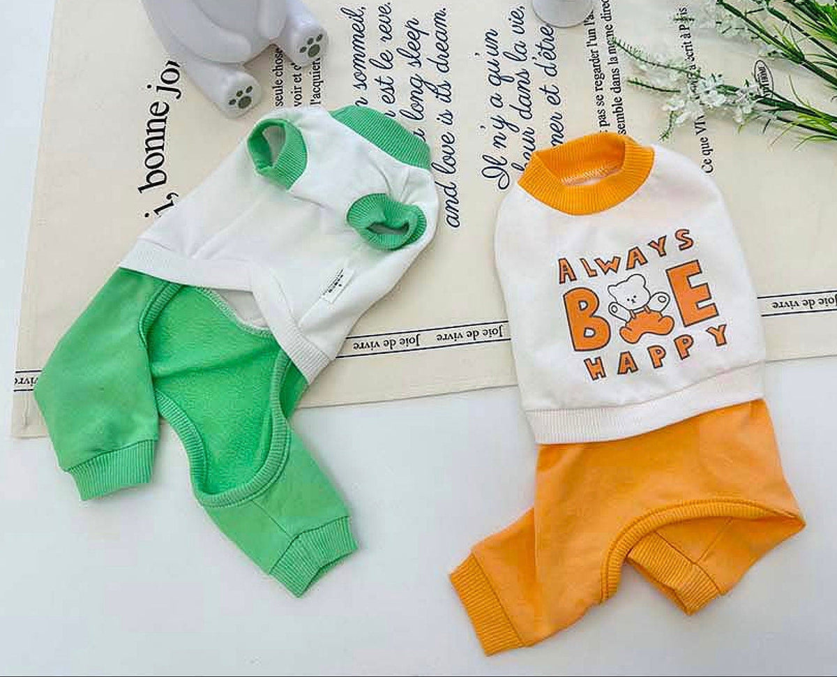Always Be Happy dog overall in white and green and orange colors with graphic text.