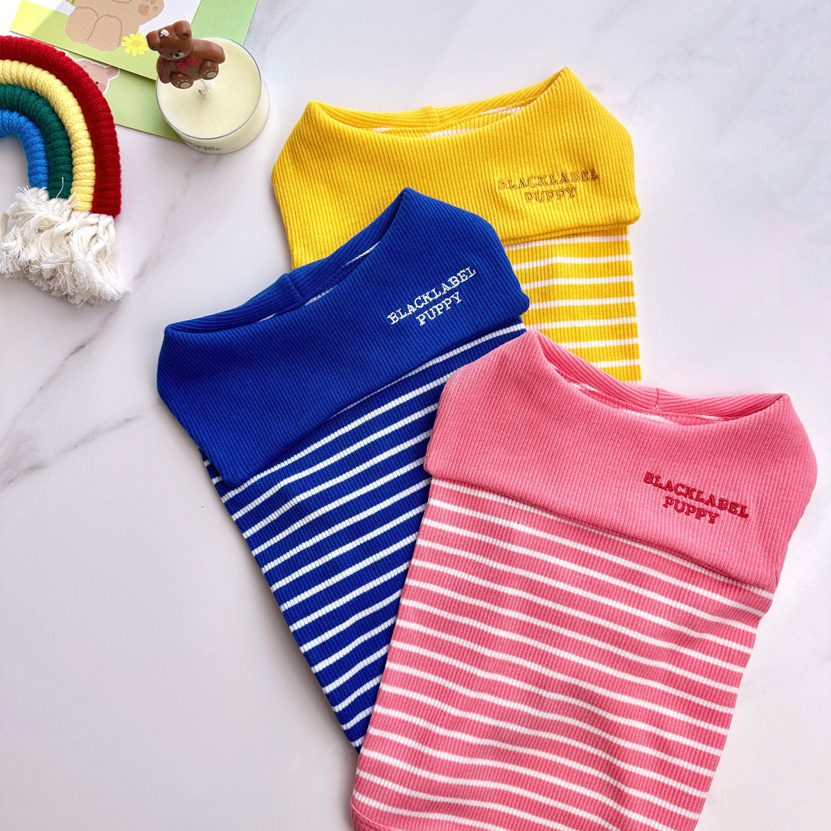 Three NKpup sailor collar striped dog shirts in yellow, blue, and pink.