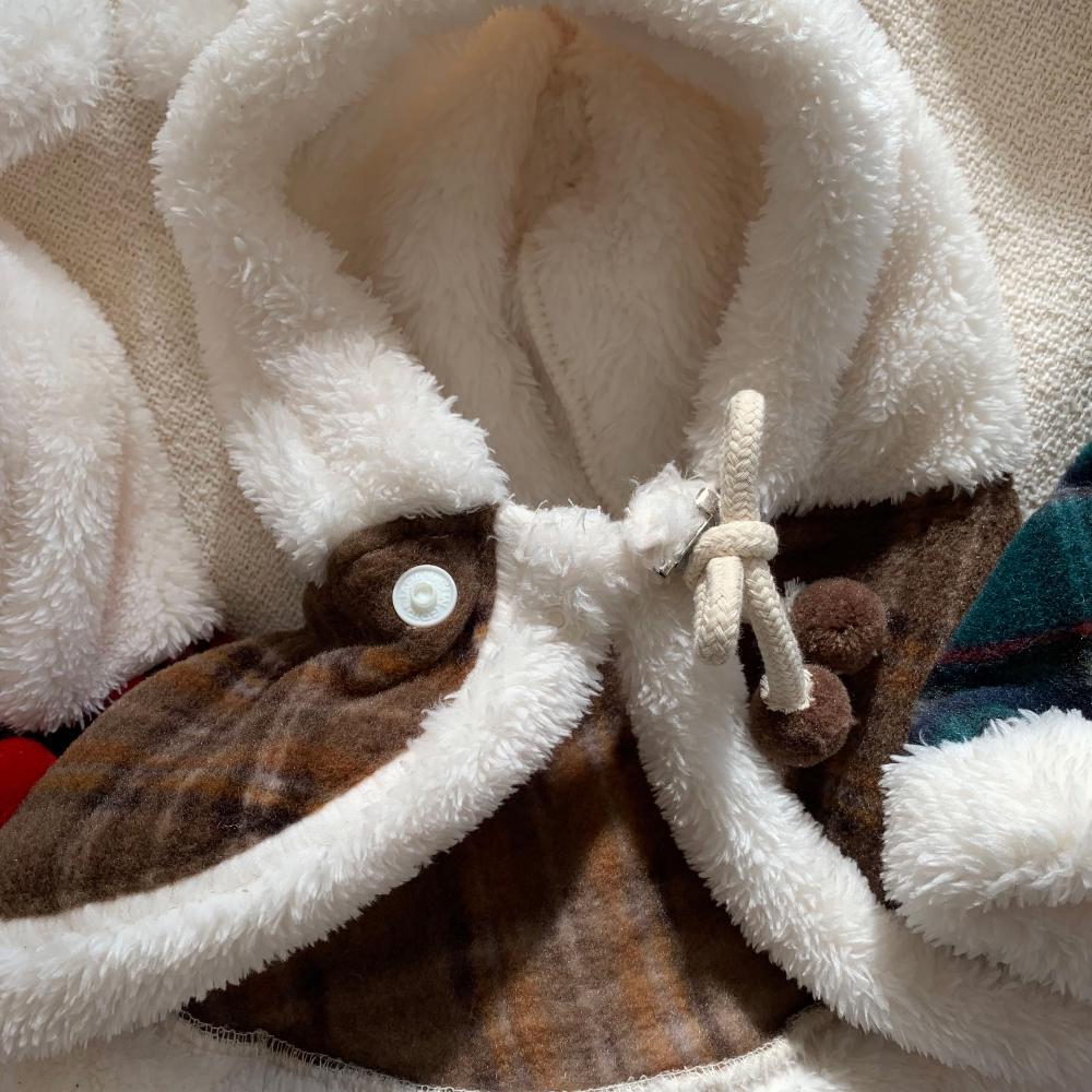 Christmas plaid dog hoodie cape with white faux fur trim and drawstring detail.