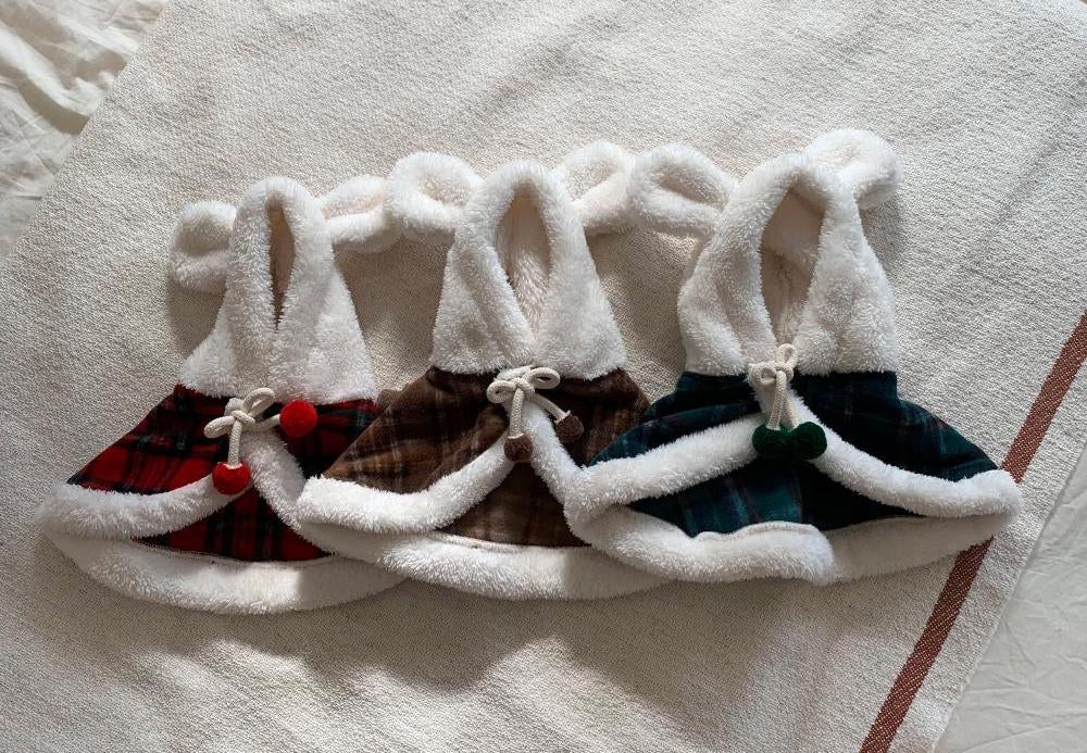 Three Christmas plaid dog hoodie capes in red, brown, and green with white faux fur trim.
