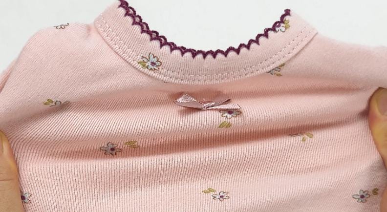 Pink floral dog romper with scalloped neckline and bow detail