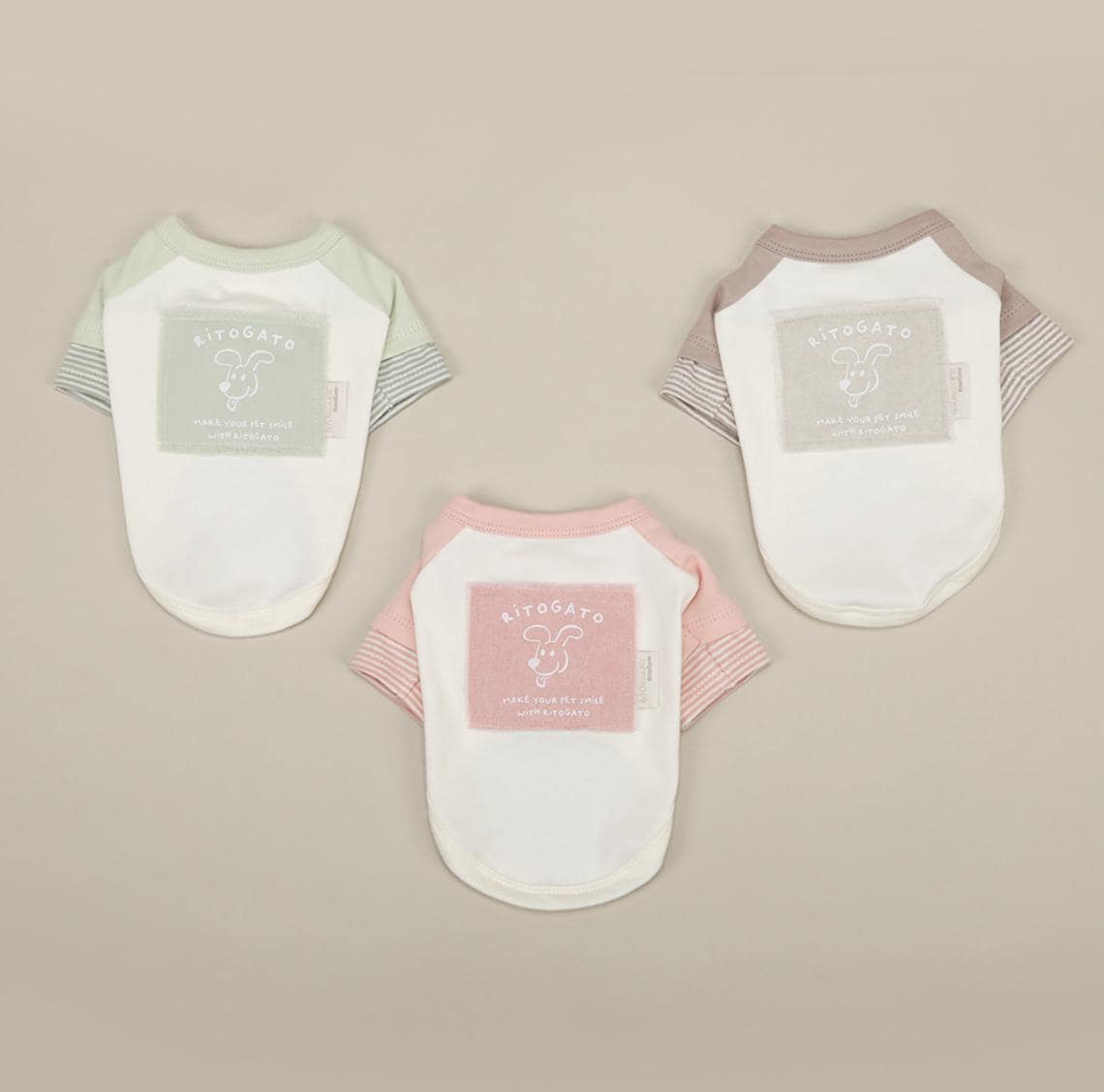 Three NKpup GOTS organic cotton pastel dog shirts in mint, beige, and pink.