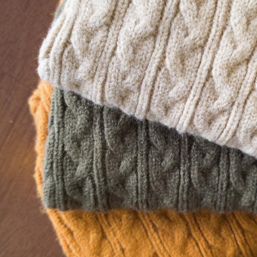 Classic cable knit dog sweaters in cream, olive green, and mustard yellow.