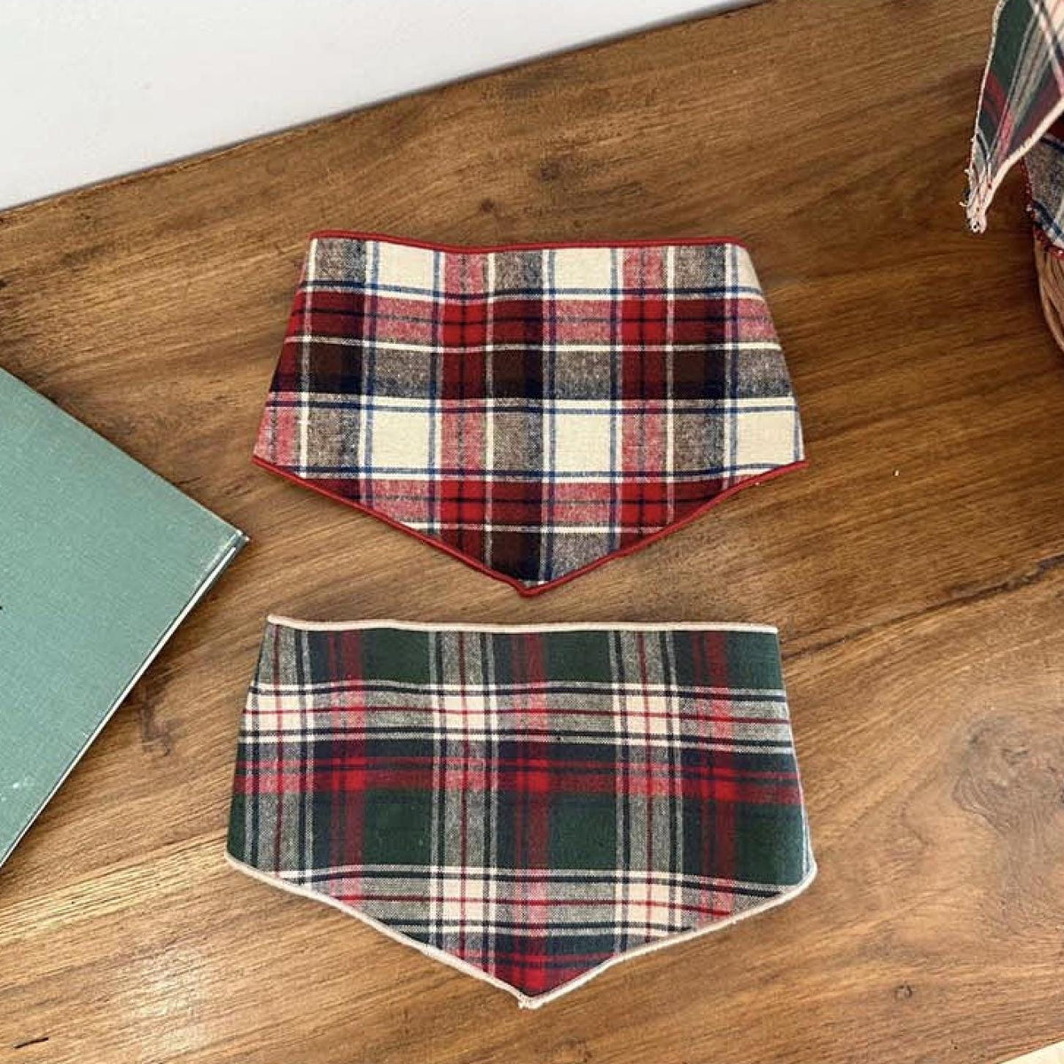 Two NKpup Cozy Plaid Scarves for dogs in red and green tartan patterns.