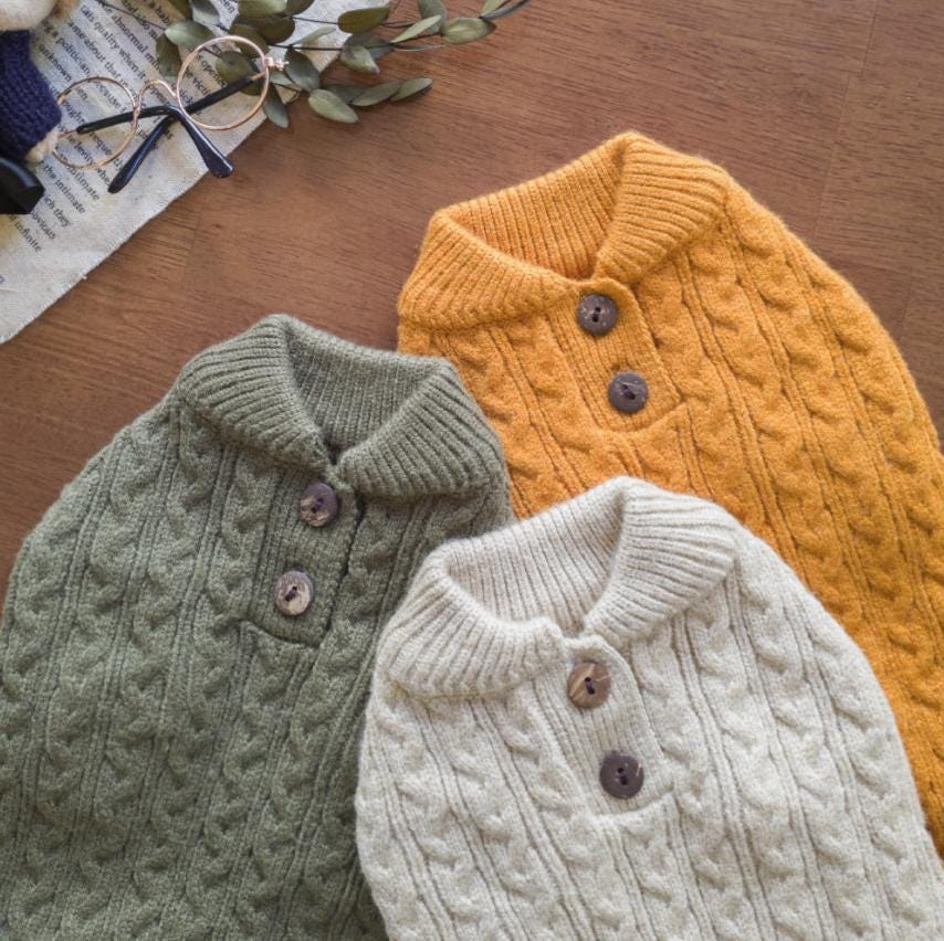 Classic cable knit dog sweaters in sage green, mustard yellow, and cream colors.