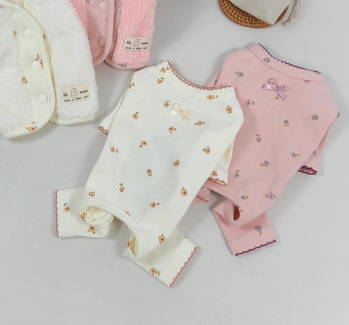 NKpup floral scalloped pet overalls in white and pink with small floral patterns and bow details.