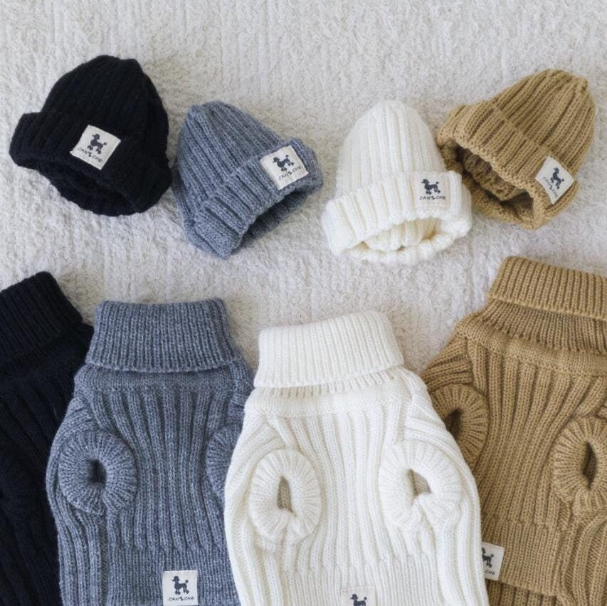 Set of ribbed turtleneck knit dog vests and matching beanies in black, grey, white, and tan colors.