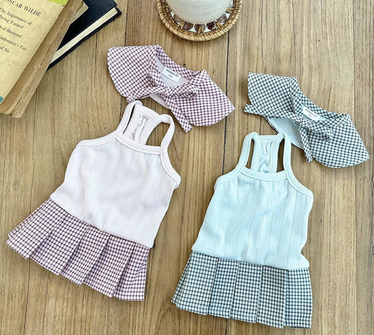 Set of three NKpup gingham collar pleated dog dresses in pink, light blue, and black and white.
